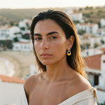 Small gold-tone hoop earrings with amber-yellow dangle charms
