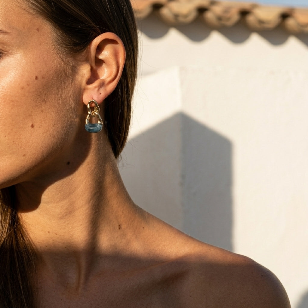 Side view: gold hoop earrings with blue teardrop charms