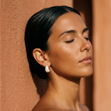 Gold-tone hoop earrings with white teardrop pearl profile