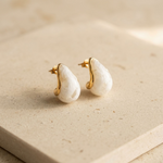 Pair of gold hoop earrings with white teardrop pearl centers