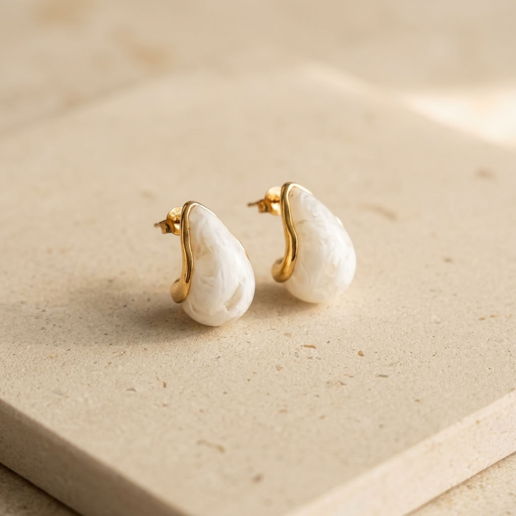 Pair of gold hoop earrings with white teardrop pearl centers