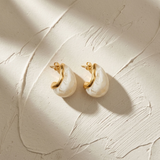 Gold-tone hoop earrings featuring white teardrop pearl drop