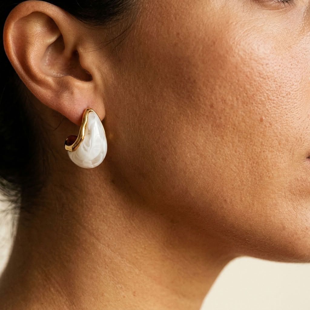 White teardrop pearl hoop earrings with gold-tone accent edges